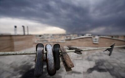 Clothes clips covered in soot from burned fuel are seen as smoke from a strike on an oil facility lingers in the cloudy sky over Tehran, Iran, March 8, 2026. (AP Photo/Vahid Salemi)