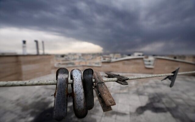 Κλιπ ρούχων καλυμμένα με αιθάλη από καμένα καύσιμα φαίνονται καθώς καπνός από χτύπημα σε πετρελαϊκή εγκατάσταση παραμένει στον συννεφιασμένο ουρανό πάνω από την Τεχεράνη, Ιράν, 8 Μαρτίου 2026. (AP Photo/Vahid Salemi)