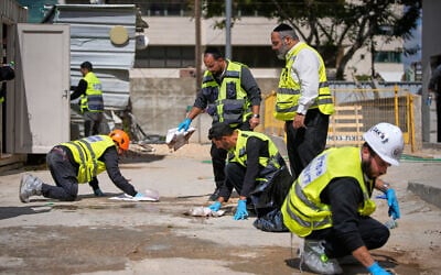 Israeli rescue teams clean bloodstains at the site where a man was killed in an Iranian missile strike in Yehud, Israel, March 9, 2026. (AP Photo/Ohad Zwigenberg)