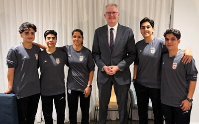 In this photo supplied by Australia's Minister for Home Affairs Tony Burke's office, the Minister Tony Burke, center, poses in an undisclosed location with five Iranian soccer players who were granted asylum in Australia on March 10, 2026. (Australia Ministry of Home Affairs via AP)
