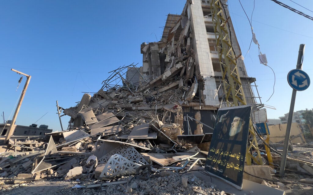 A portrait of late Hezbollah leader Hassan Nasrallah sits in front of a destroyed building that housed a branch of Al-Qard Al-Hassan, a non-bank financial institution run by Hezbollah, which was hit by an Israeli airstrike in Dahiyeh, Beirut's southern suburbs, Lebanon, March 10, 2026. (AP/Hussein Malla)