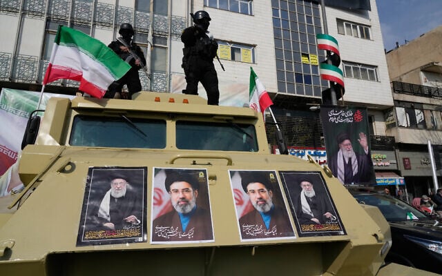 Policemen stand on top of their car with pictures of the late Iranian supreme leader Ayatollah Ali Khamenei, right and left, and his son and successor Ayatollah Mojtaba Khamenei during a rally in Tehran, Iran, March 9, 2026. (AP/Vahid Salemi)