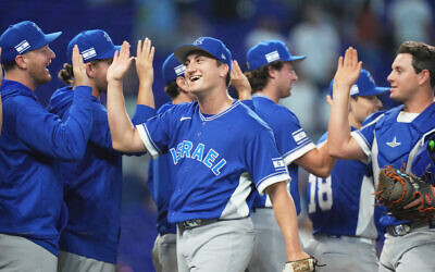 Israel pitcher Ben Simon, center, high-fives his teammates after Israel defeated the Netherlands during a World Baseball Classic game, Tuesday, March 10, 2026, in Miami. (AP /Lynne Sladky)