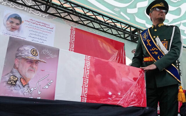 A Revolutionary Guard member stands next to the coffins of the guard's commander Mohammad Pakpour, bottom, and a girl, during the funeral procession for senior Iranian military officials and some civilians killed during the US-Israel campaign in Tehran, Iran, March 11, 2026. (Vahid Salemi/AP)