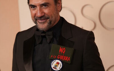 Javier Bardem arrives at the Oscars wearing 'No to war' and Handala pins on March 15, 2026, at the Dolby Theatre in Los Angeles. (AP Photo/Gregory Bull)