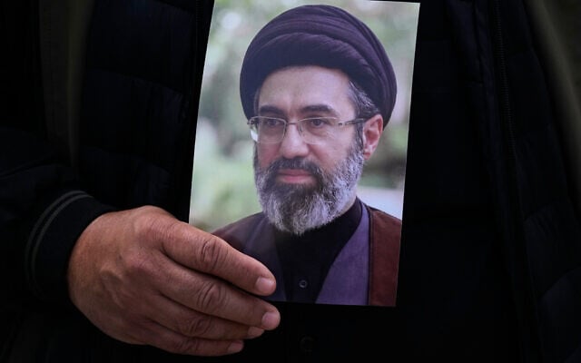 A man holds a poster Iranian Supreme Leader Ayatollah Mojtaba Khamenei during the funeral procession of Gen. Ali Mohammad Naini, a spokesperson for Iran’s Islamic Revolutionary Guard Corps and one of his comrades Amir Hossein Bidi in Tehran, Iran, March 21, 2026.Falco