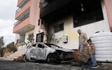 Palestinians inspect a torched vehicle following Israeli settlers' rampage through nearby Nablus-area villages on Sunday night, in West Bank village of Deir al-Hatab, Monday, March 23, 2026. (AP/Majdi Mohammed)