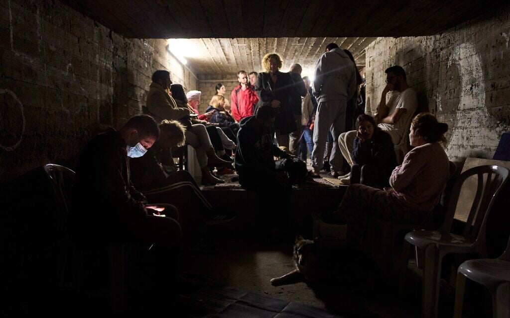 People gather in a bomb shelter as air raid sirens warn of incoming missiles from Iran in Ramat Gan, Israel, Sunday, March 22, 2026. (AP Photo/Oded Balilty)