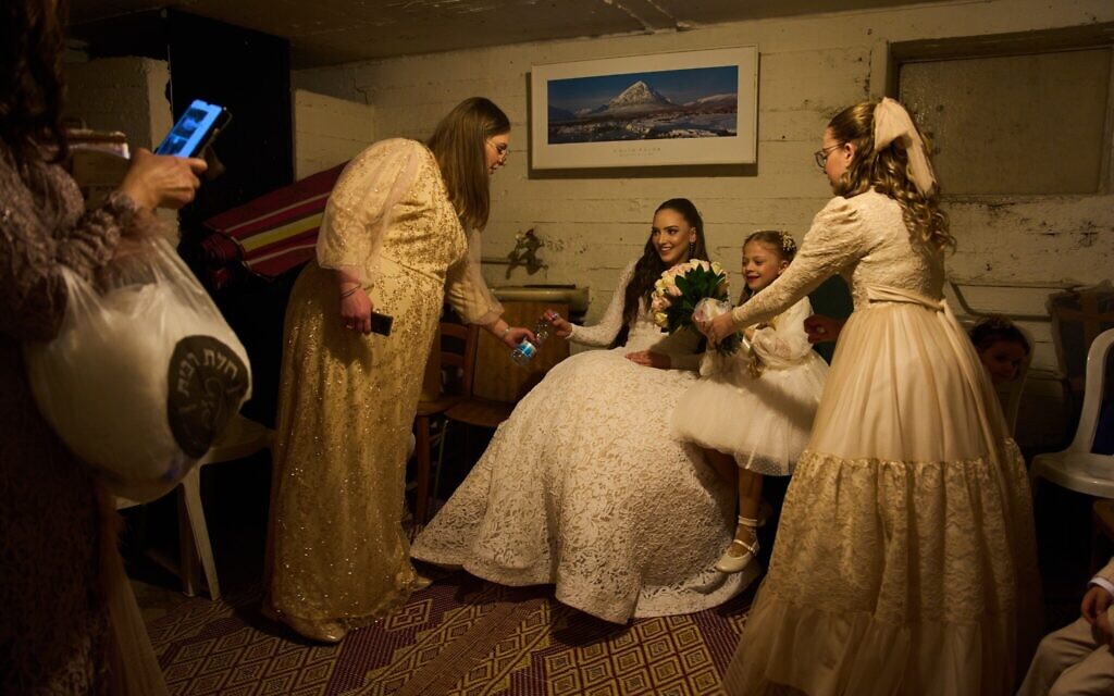 A bride and her family sit in a bomb shelter after an alert warning of missiles fired from Iran at central Israel interrupted their wedding photo shoot in a nearby park in Ramat Gan, March 19, 2026. (AP Photo/Oded Balilty)
