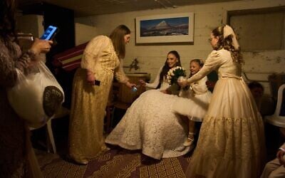 A bride and her family sit in a bomb shelter after an alert warning of missiles fired from Iran at central Israel interrupted their wedding photo shoot in a nearby park in Ramat Gan, March 19, 2026. (AP Photo/Oded Balilty)