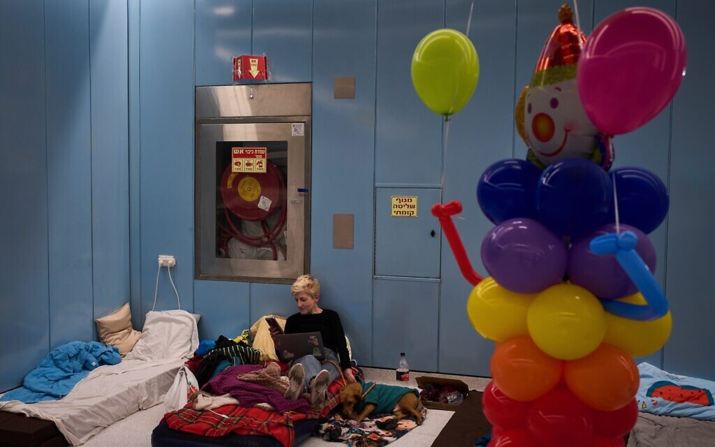 A woman sits on a mattress in an underground metro station serving as a bomb shelter amid Iranian missile attacks during the Jewish holiday of Purim in Ramat Gan, March 2, 2026. (AP Photo/Oded Balilty)