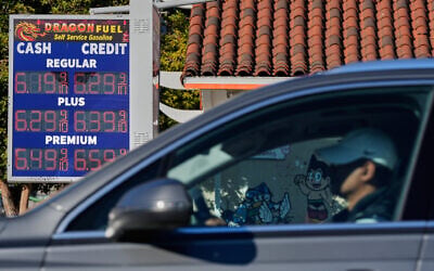 A motorist drives past a sign displaying prices at a gas station, in Oakland, California, March 24, 2026. (AP Photo/Godofredo A. Vásquez)