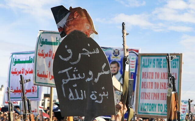 Houthi supporters shout slogans during a rally against Israel and the United States' war in Iran, in Sanaa, Yemen, March 27, 2026. The sign in Arabic reads, "we will remove your throne." (AP Photo/Osamah Abdulrahman)