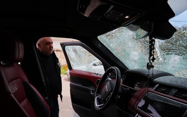 A man inspects a vehicle with shattered windows following overnight violence in the predominantly Christian town of Al-Suqaylabiyah, west of Hama, Syria, March 28, 2026. (AP Photo/Omar Albam)