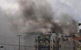Illiustration: Portraits of Hezbollah's late leaders Hassan Nasrallah, right, and his cousin, Hashem Safieddine, are seen as smoke rises following an Israeli airstrike in Dahiyeh, Beirut's southern suburbs, March 30, 2026. (AP/Hassan Ammar)