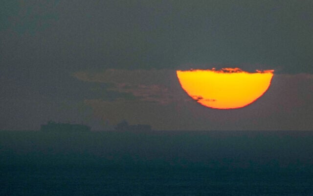 Ships sail through the Arabian Gulf toward the Strait of Hormuz as the sun sets in the United Arab Emirates, March 23, 2026. (AP Photo)
