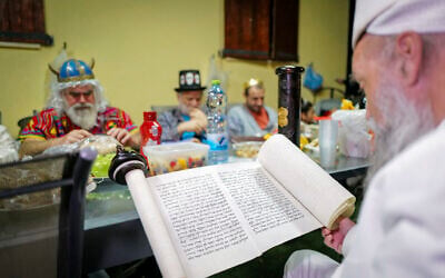 Jews read the Megillat Esther (the Book of Esther) on the eve of the Jewish holiday of Purim, in Katzrin, northern Israel, on March 13, 2025. (Michael Giladi/Flash90)