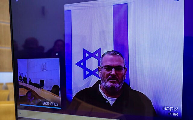 Bezalel Zini, accused of smuggling cigarettes into the Gaza Strip, is seen on a screen at the District Court in Beer Sheva, ahead of the filing of an indictment against him, on February 5, 2026. (Tsafrir Abayov/Flash90) Bezalel Zini, accused of smuggling cigarettes into the Gaza Strip, is seen on a screen at the District Court in Beer Sheva, ahead of the filing of an indictment against him, on February 5, 2026. (Tsafrir Abayov/Flash90)