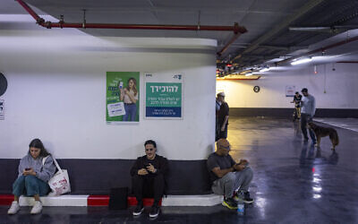 Israelis take cover at an underground parking lot in Tel Aviv as a siren sounds warning of incoming ballistic missiles fired from Iran toward Israel, March 5, 2026. (Chaim Goldberg/Flash90)