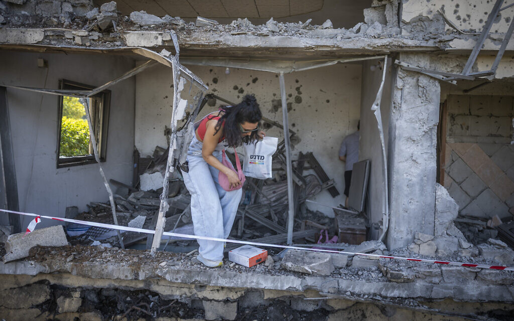 People at a home that was hit by a Hezbollah rocket in Moshav Haniel in central Israel, March 12, 2026. (Chaim Goldberg/Flash90) People at a home that was hit by a Hezbollah rocket in Moshav Haniel in central Israel, March 12, 2026. (Chaim Goldberg/Flash90)