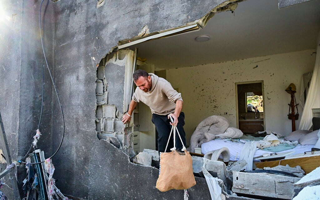 A man collects items from a house damaged overnight by an Iranian missile overnight, in Zarzir, northern Israel, March 13, 2026.(Michael Giladi/Flash90) A man collects items from a house damaged overnight by an Iranian missile overnight, in Zarzir, northern Israel, March 13, 2026.(Michael Giladi/Flash90)