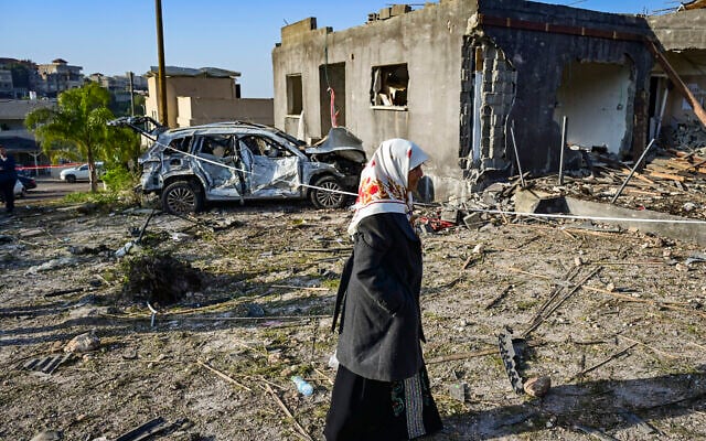 People look at the damage after a missile fired toward Israel overnight struck the Bedouin town of Zarzir, in northern Israel, March 13, 2026. (Michael Giladi/Flash90) People look at the damage after a missile fired toward Israel overnight struck the Bedouin town of Zarzir, in northern Israel, March 13, 2026. (Michael Giladi/Flash90)