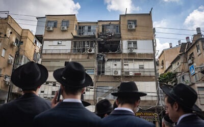 Israeli srcurity and rescue forces inspect the damage at the scene where a missile fired from Iran toward Israel caused damage in Bnei Brak, central Israel, March 15, 2026. (Chaim Goldberg/Flash90)