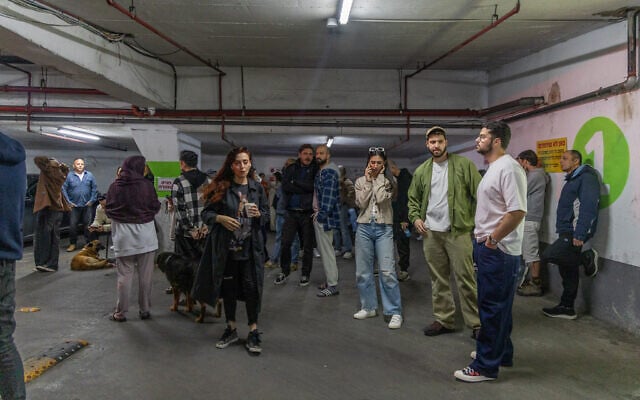 People take cover in a bomb shelter after missiles are fired by Iran, in Tel Aviv, March 22, 2026. (Yossi Aloni/Flash90) People take cover in a bomb shelter after missiles are fired by Iran, in Tel Aviv, March 22, 2026. (Yossi Aloni/Flash90)