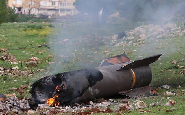 Israeli security at the scene where an Iranian missile fragment fell in an open area in the northern Israeli city of Safed, March 23, 2026. (David Cohen/Flash90)