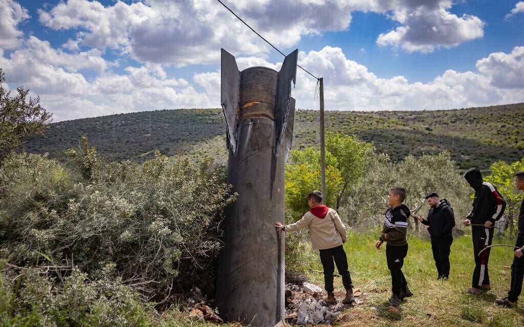 Palestinians surround debris from a ballistic missile fired from Iran toward Israel that fell outside the Palestinian village of Haris in the West Bank, on March 24, 2026. (Chaim Goldberg/Flash90) Palestinians surround debris from a ballistic missile fired from Iran toward Israel that fell outside the Palestinian village of Haris in the West Bank, on March 24, 2026. (Chaim Goldberg/Flash90)