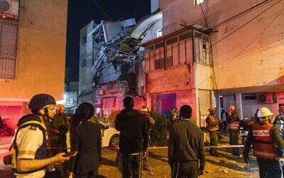 Onlookers and rescue forces inspect damage at the scene where a cluster munition from an Iranian ballistic missile struck in Bnei Brak, March 24, 2026. (Chaim Goldberg/Flash90)
