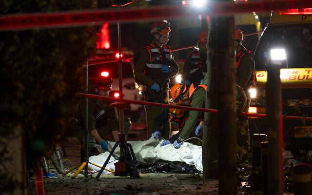 Israeli security and rescue forces at the scene where a missile fired from Iran killed one person in Tel Aviv, March 28, 2026. (Flash90) Israeli security and rescue forces at the scene where a missile fired from Iran killed one person in Tel Aviv, March 28, 2026. (Flash90)