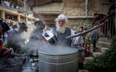 Ultra-Orthodox Jews immerse cooking pots in boiling water to remove any traces of leavening (hametz) in preparation for the upcoming Passover holiday, in the ultra-Orthodox neighborhood of Mea Shearim in Jerusalem, March 31, 2026. (Yonatan Sindel/Flash90)