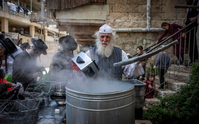Ultra-Orthodox Jews immerse cooking pots in boiling water to remove any traces of leavening (hametz) in preparation for the upcoming Passover holiday, in the ultra-Orthodox neighborhood of Mea Shearim in Jerusalem, March 31, 2026. (Yonatan Sindel/Flash90)