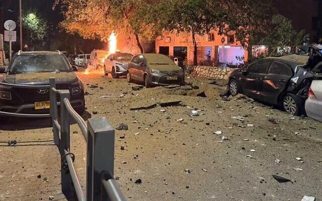 Damage is seen on a road in central Israel from an Iranian cluster missile, early March 18, 2026. (Magen David Adom)