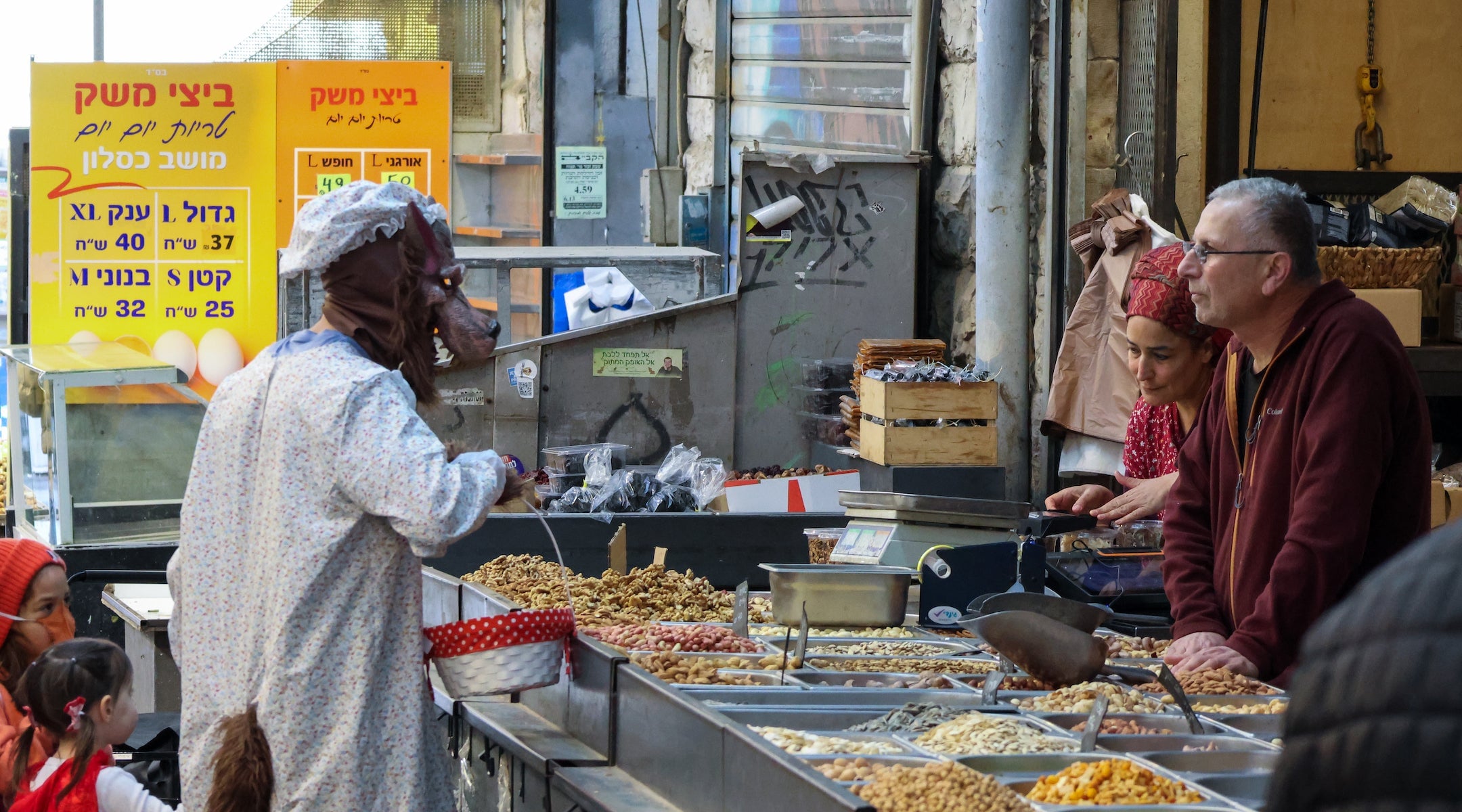 A man wearing a wolf costume with his daughter dressed as Little Red Riding Hood shops at a stall in the Mahane Yehuda market in Jerusalem, which was operating at limited capacity because of the war with Iran, during Purim in Jerusalem, March 4, 2026. (Theia Chatelle/ JTA) A man wearing a wolf costume with his daughter dressed as Little Red Riding Hood shops at a stall in the Mahane Yehuda market in Jerusalem, which was operating at limited capacity because of the war with Iran, during Purim in Jerusalem, March 4, 2026. (Theia Chatelle/ JTA)