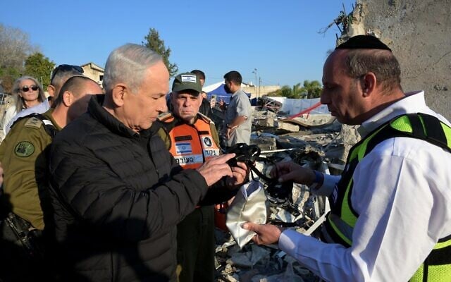 This handout photo shows Prime Minister Benjamin Netanyahu visiting the site of a deadly Iranian missile attack in Beit Shemesh, March 2, 2026. (GPO/ Avi Ohayon)