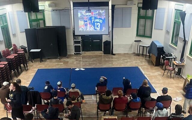 Fans watch Israel's baseball team take on the Dominican Republic in a Jerusalem assembly hall on March 9, 2026. (Courtesy Callie Mitchell)