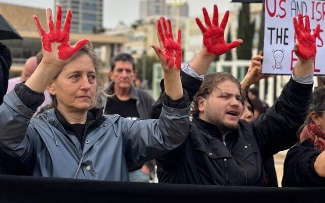 Protesters against the war with Iran hold up red-painted hands at Tel Aviv’s Habima Square, March 21, 2026. (Courtesy Hadash party)
