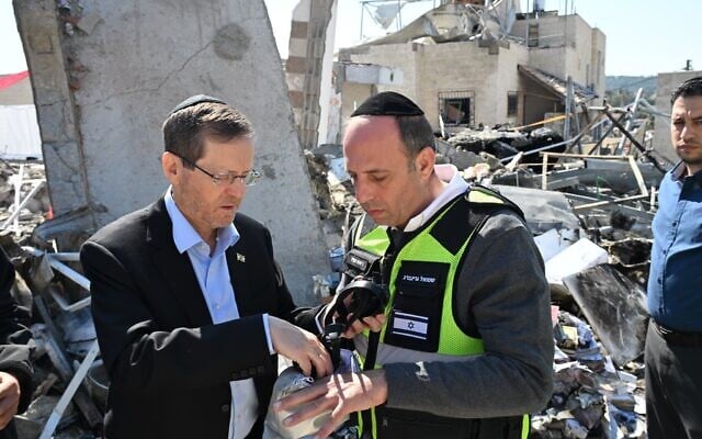 President Isaac Herzog (L), alongside Beit Shemesh Mayor Shmuel Greenberg, visits the site of an Iranian missile attack in Beit Shemesh, which resulted in the death of nine civilians. March 2, 2026. (Haim Zach/GPO)