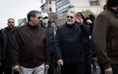 Ali Larijani (waving) participates in a Quds Day anti-Israel march in Tehran on March 13, 2026, the last time he was seen alive in public. (X, used in accordance with clause 27a of the copyright law)