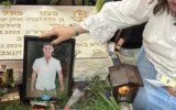 Varda Morrell lays a photo at the gravesite of her son, IDF Staff Sgt. Maoz Morell, in 2025. (Courtesy Varda Morell via JTA)