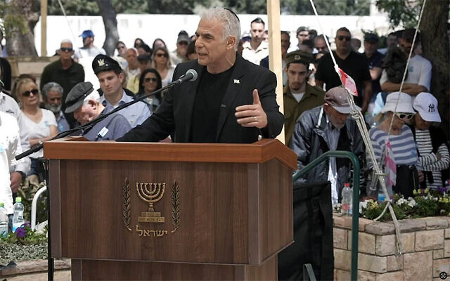Opposition Leader Yair Lapid speaks at a Memorial Day ceremony, at the Herzliya military cemetery, April 21, 2026. (Yesh Atid video screenshot)