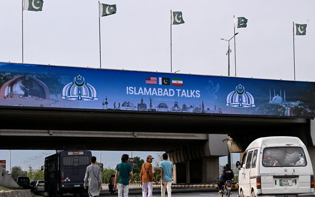 Boys walk under a digital screen displaying news of USIran peace talks along a road in Islamabad on April 10, 2026. A cloud of uncertainty hung April 10 over the scheduled start of talks in Pakistan between the United States and Iran, with no announcement yet on the arrival of negotiators and both sides accusing the other of failing to properly implement a fragile ceasefire. (Photo by Farooq NAEEM / AFP) Boys walk under a digital screen displaying news of USIran peace talks along a road in Islamabad on April 10, 2026. A cloud of uncertainty hung April 10 over the scheduled start of talks in Pakistan between the United States and Iran, with no announcement yet on the arrival of negotiators and both sides accusing the other of failing to properly implement a fragile ceasefire. (Photo by Farooq NAEEM / AFP)