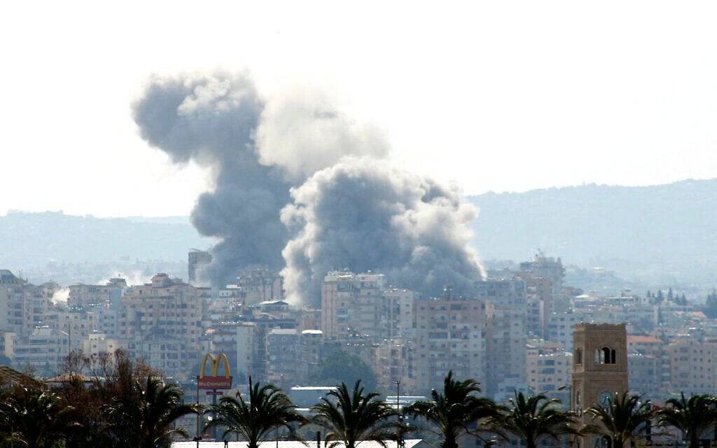 Smoke rises behind palm trees and a McDonald's 'Golden Arches' logo from the site of an Israeli airstrike that targeted the Al-Hosh area near the coastal Lebanese city of Tyre on April 14, 2026. (Kawnat HAJU / AFP)