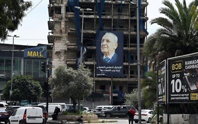 A giant poster of Lebanese Parliament Speaker Nabih Berri, under which reads "Coexistence between Muslims and Christians is a valuable treasure that must be preserved," hangs on a building at the entrance of Beirut's southern suburbs Hadath neighborhood on April 14, 2026. (Joseph EID / AFP)