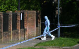 A police forensic officer works inside a cordon set up near Kenton United Synagogue in Harrow, northwest London, on April 19, 2026, the scene of an overnight arson attack. (JUSTIN TALLIS / AFP)