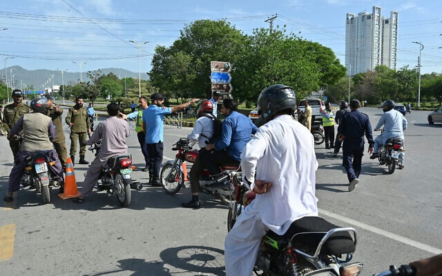 Ahead of planned US-Iran talks, security personnel guide commuters for alternate routes from a checkpoint near the Serena Hotel, at the Red Zone area in Islamabad, Pakistan, on April 21, 2026. (Asif HASSAN / AFP)