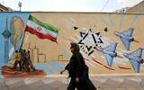 An Iranian woman walks past an anti-Israel mural, in Tehran on April 21 2026. (ATTA KENARE / AFP) /