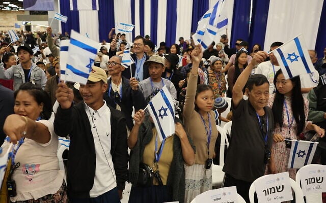 Members of the Bnei Menashe community from India wave Israeli flags as they arrive at Ben Gurion Airport in Lod on April 23, 2026. (Jack Guez/AFP)